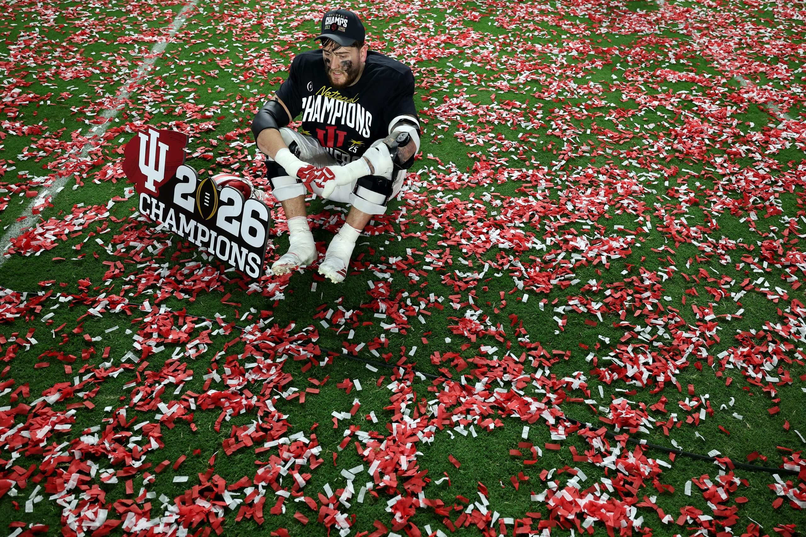 Zen Michalski of the Indiana Hoosiers sits among confetti on the field after Indiana defeated Miami.