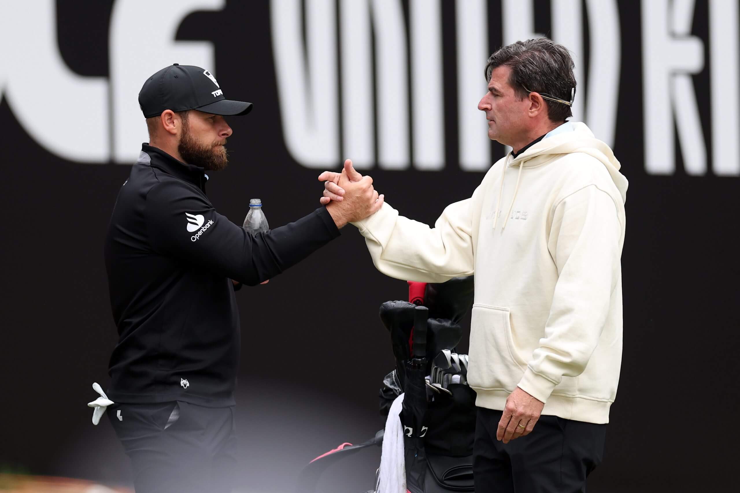 LIV Golf CEO Scott O'Neil, right, shakes hands with Tyrrell Hatton. 