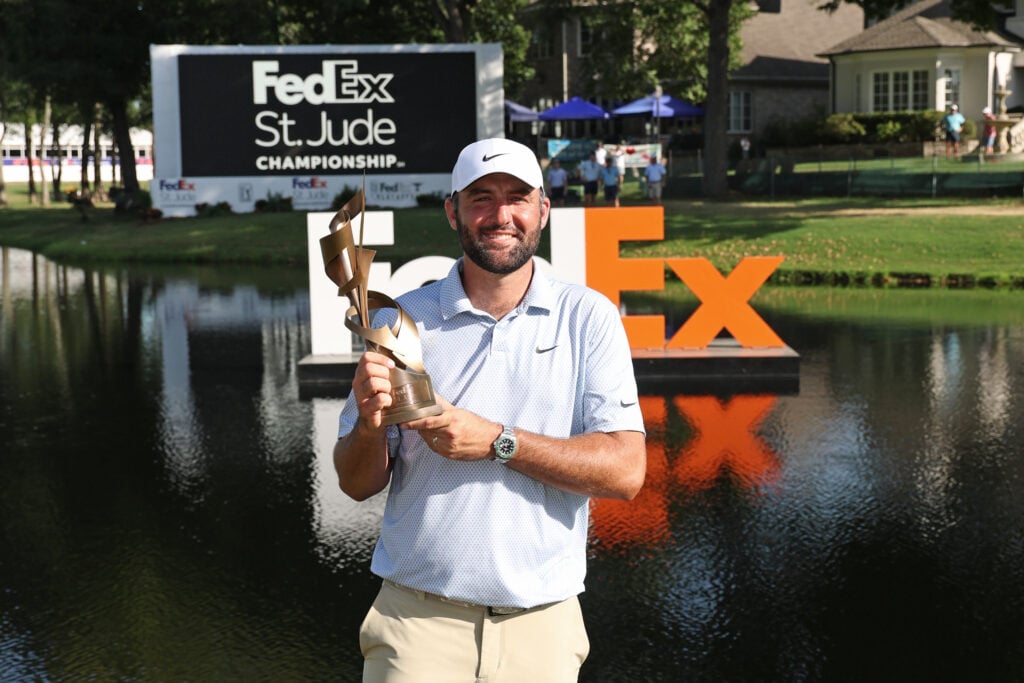 Scottie Scheffler holds up the trophy after winning the FedEx St. Jude Championship