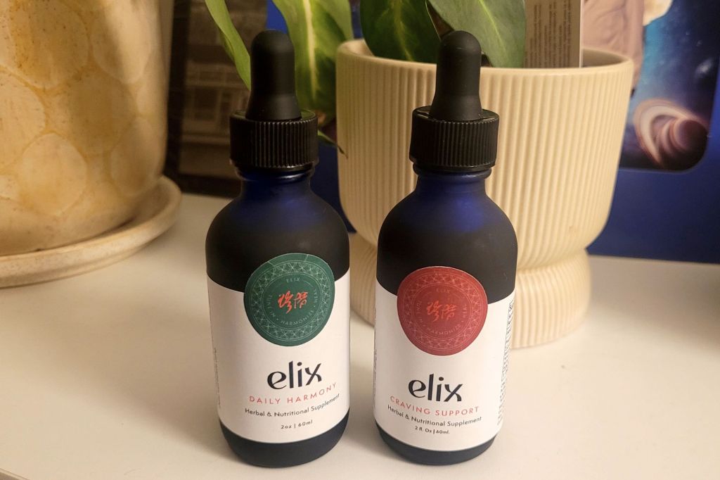 Two bottles of Chinese medicine tinctures on a credenza
