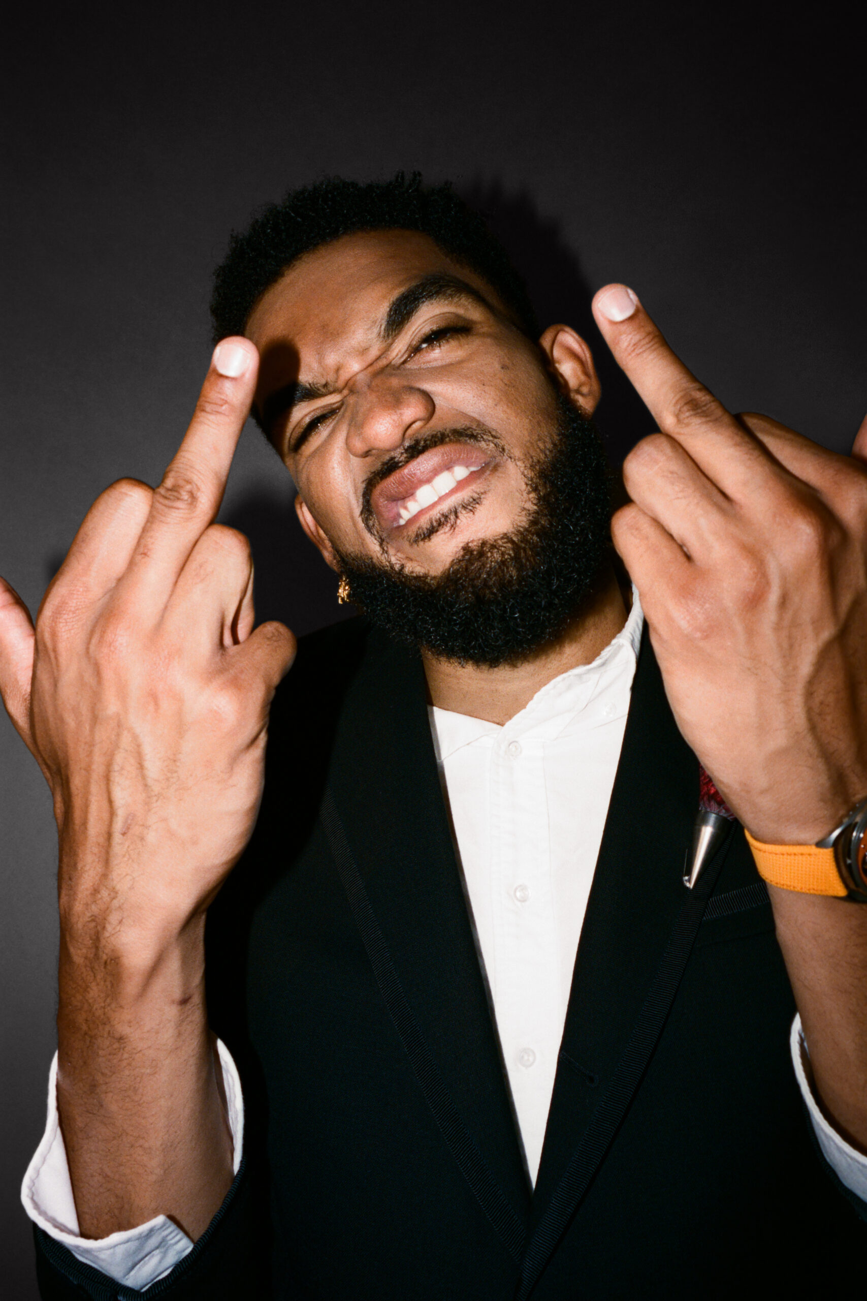 Karl Anthony Towns bites his lip and holds up two middle fingers to the camera.