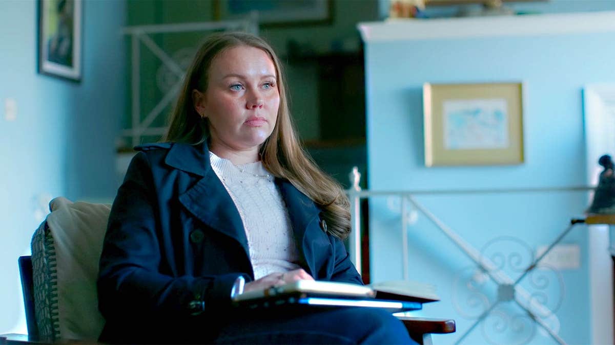 Kara Robinson Chamberlain looking up while holding cold case files.