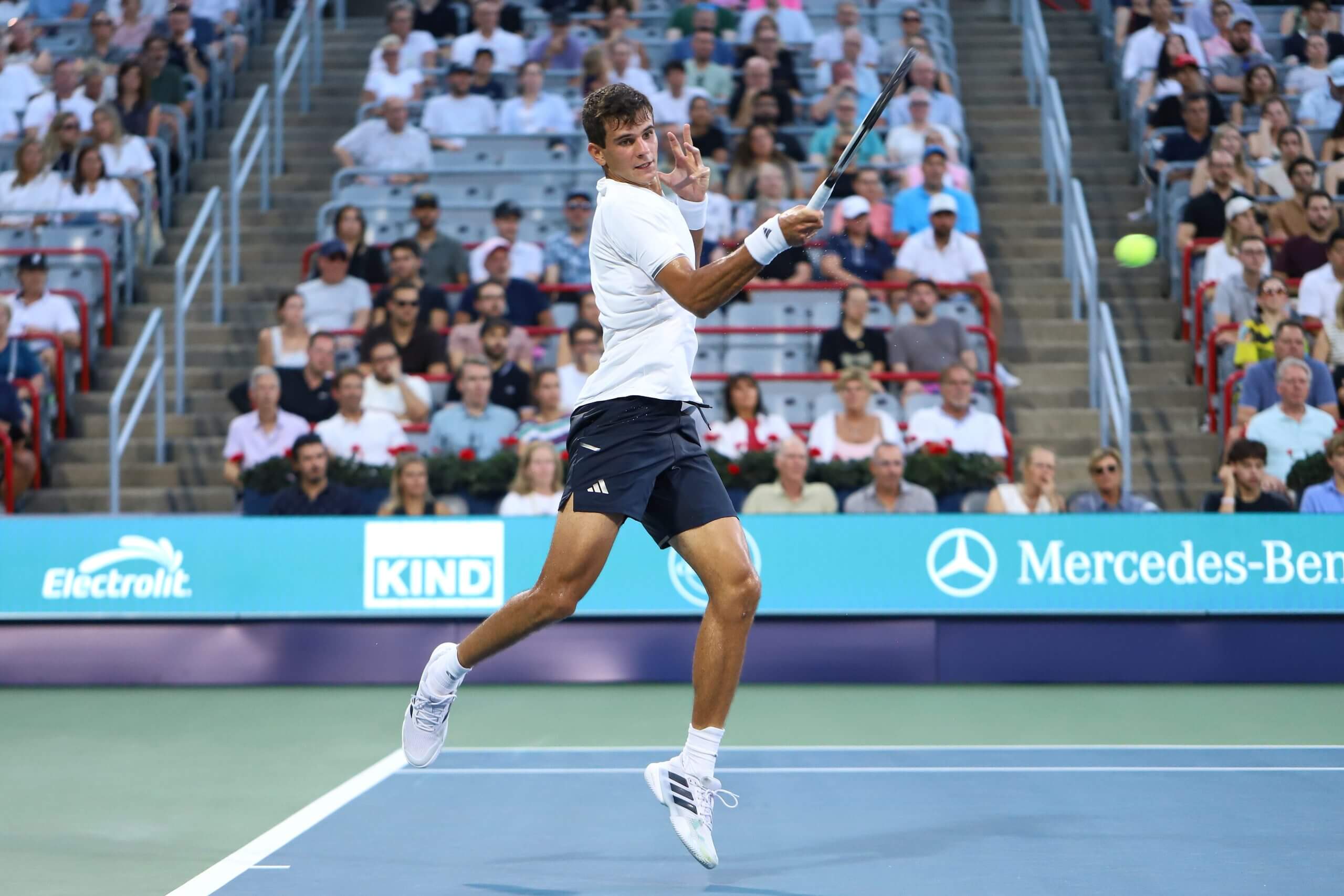 Rafael Jódar hits a forehand in front of the baseline of a tennis court at full extension.