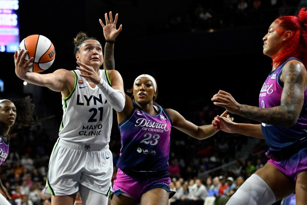 Kayla McBride of the Lynx shoots the ball defended by Cotie McMahon (23) and Shakira Austin (0) of the Washington Mystics during Friday's game in Washington, DC. (Photo by Hannah Foslien/Getty Images)