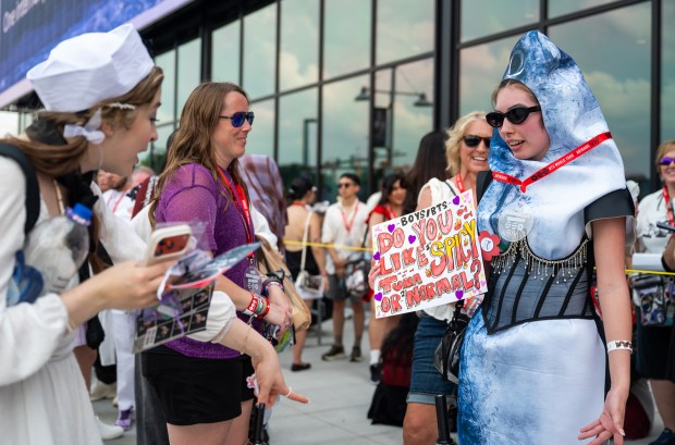 BTS fan Lexi Hoyt, 23, shows off her tuna costume and sign to fans passing by outside M&T Bank Stadium. Hoyt, who has attended six BTS concerts, traveled from Arkansas to attend the 16th stop of the group's "Arirang" World Tour in Baltimore. As temperatures climbed, Hoyt joked about her outfit: "I'm spicy tuna because I'm hot she said.  (Ryan Bowie/Staff)