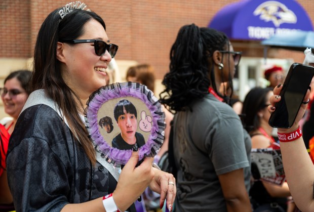 Sabrina Kong, 36, holds up a sign featuring BTS member Jung Kook as she waits in line for the BTS concert at M&T Bank Stadium. Kong traveled from California to attend the concert and celebrate her birthday. (Ryan Bowie/Staff)