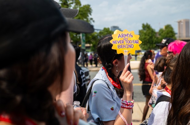 New Jersey resident Amy Ni, 26, holds up a sign referencing BTS' fan base, ARMY (Adorable Representative M.C. for Youth), as she enters M&T Bank Stadium for sound check, five hours before the concert. (Ryan Bowie/Staff)