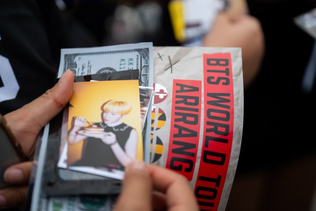 BTS freebies, including stickers and small keepsakes, were traded among fans outside M&T Bank Stadium before the concert. (Ryan Bowie/Staff)