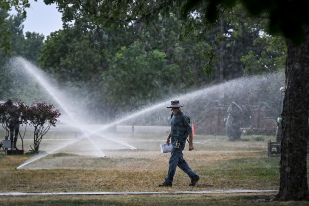 Kevin Hoover works with a crew to water the grass at Benson Sculpture Garden in Loveland on Thursday, Aug. 13, 2026. Crews worked to repair the grass for an event after two weeks of not watering. (Photo by AAron Ontiveroz/The Denver Post)