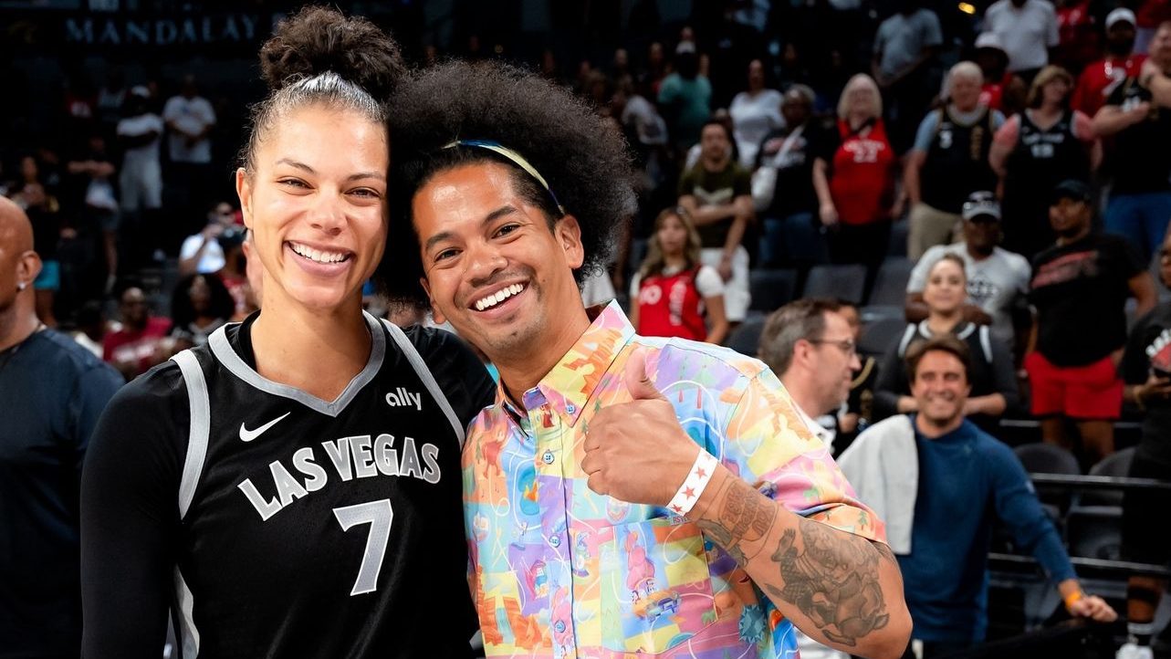 Alysha Clark (left) and librarian Mychal Threets (right) take a photo before one of the Las Vegas Aces' home games in 2024.