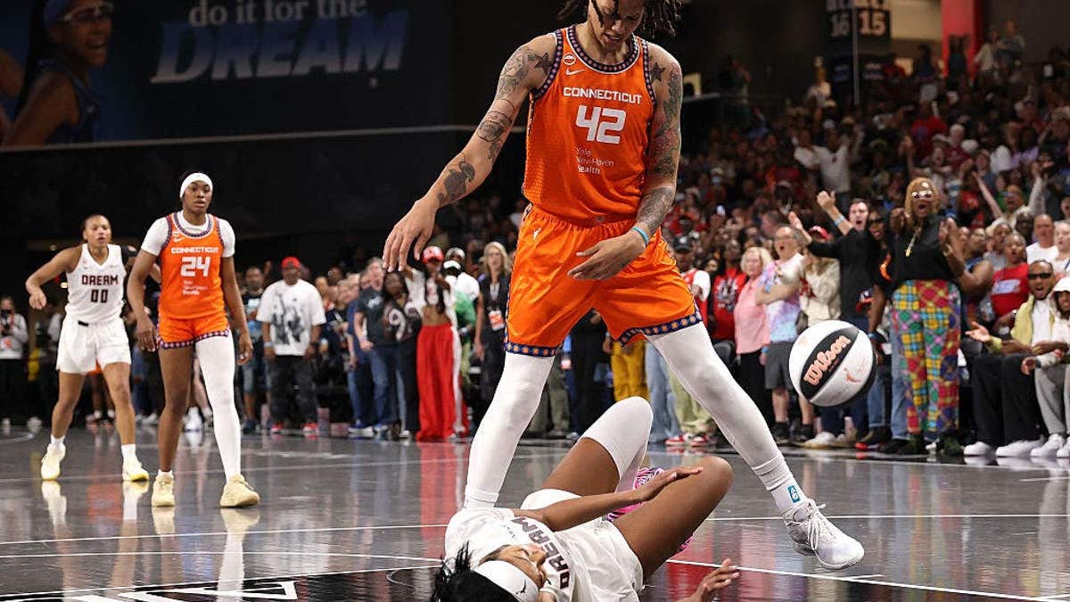 Angel Reese drawing a foul against Brittney Griner during a basketball game