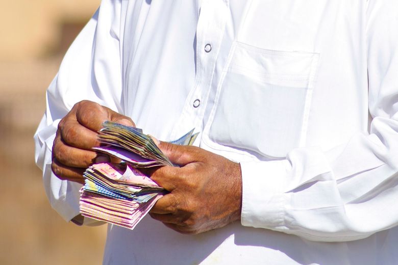 A camel dealer counts his money at the camel market on the outskirts of Al Ain.