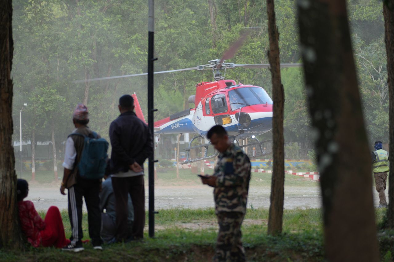 People wait outside an army camp for updates and assistance in the rescue of their family members following devastating flash floods at Trisuli in Nuwakot, Nepal, on Thursday.