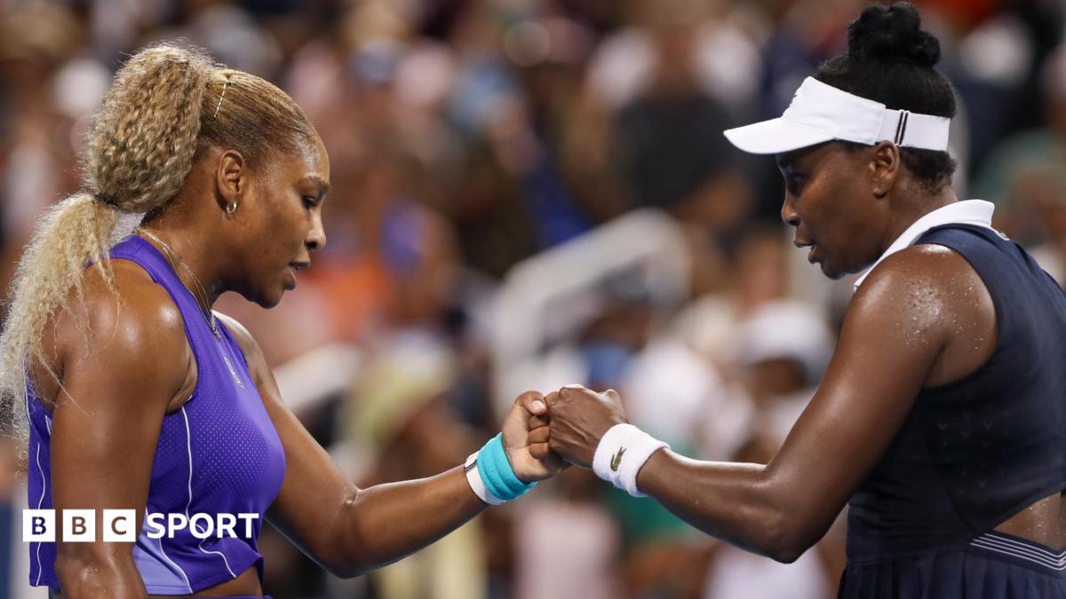 Serena Williams bumps fists with Venus Williams during their first round match at the Cincinnati Open