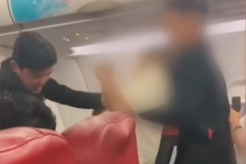 Two male cabin attendants restrain the Thai man who was later confirmed to be a lieutenant in the Royal Thai Army with mental health issues. (Photo: screenshot from Social Hunter 2022 page)