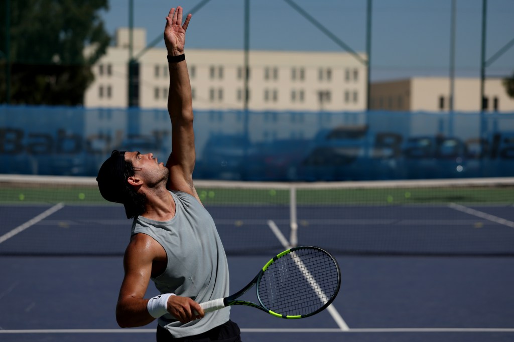 Carlos Alcaraz serving during a tennis practice session.