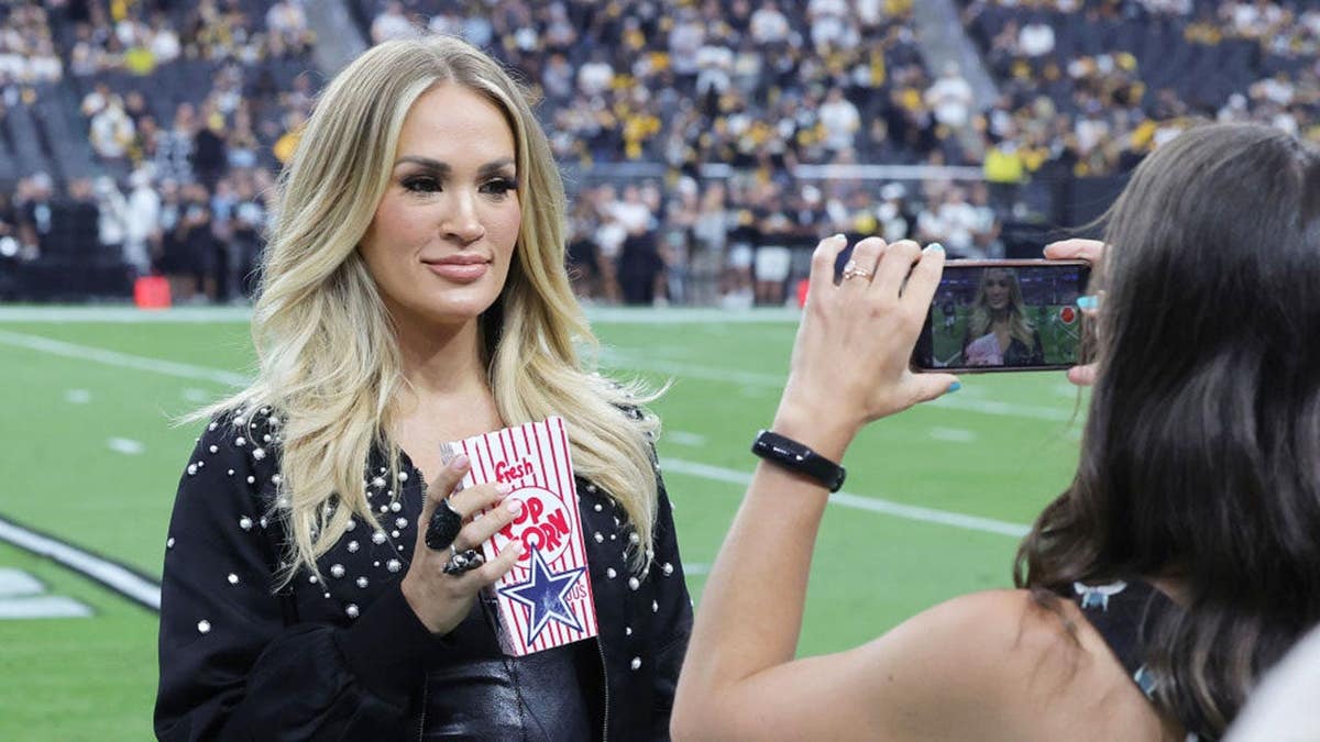 Carrie Underwood films a promo on the field at Allegiant Stadium.