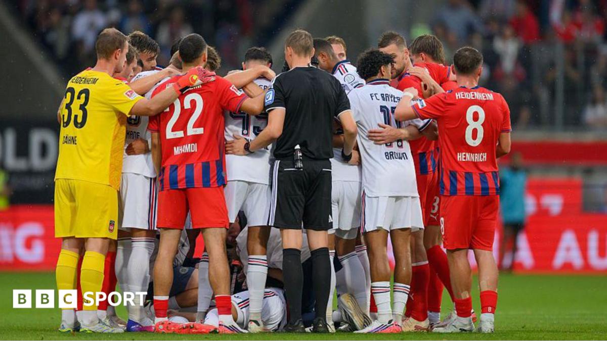 Bayern Munich and Heidenheim players surround Jamal Musiala following his collapse during a pre-season friendly on 18 August 2026