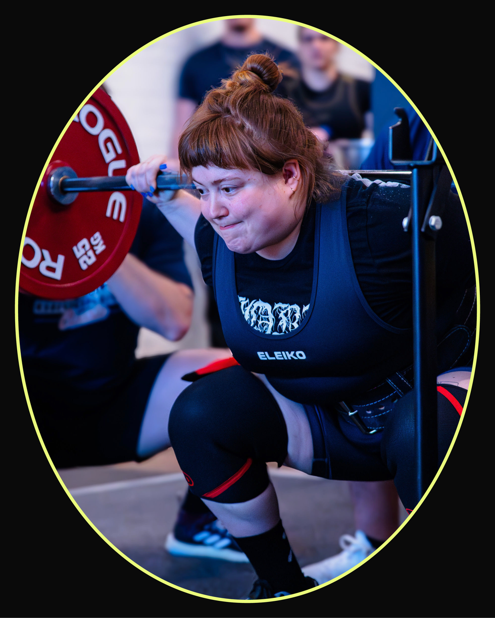 A competitor squatting with a loaded barbell during a powerlifting event.