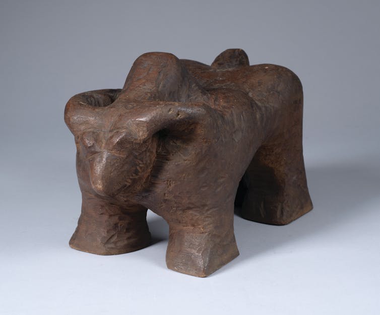 An abstract wooden sculpture of a buffalo