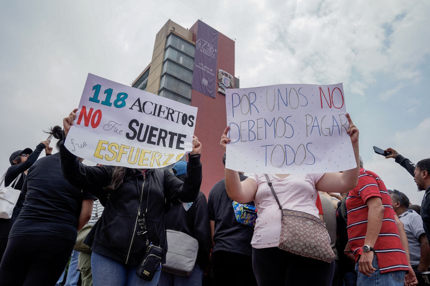 Mothers of university applicants hold protest posters during a demonstration at the UNAM Rectory in Mexico City, on July 28, following the discovery of inconsistencies in the online application process for the university entrance exam.