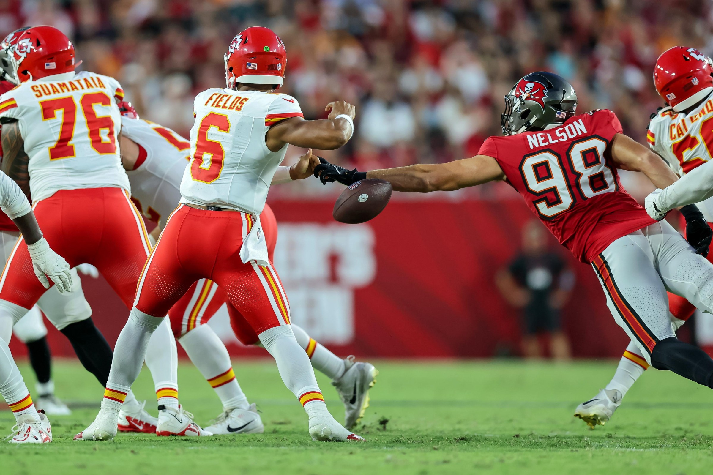 TAMPA, FLORIDA - AUGUST 22: Anthony Nelson #98 of the Tampa Bay Buccaneers strips the ball from Justin Fields #6 of the Kansas City Chiefs during the first half of a preseason game at Raymond James Stadium on August 22, 2026 in Tampa, Florida. (Photo by Mike Carlson/Getty Images)