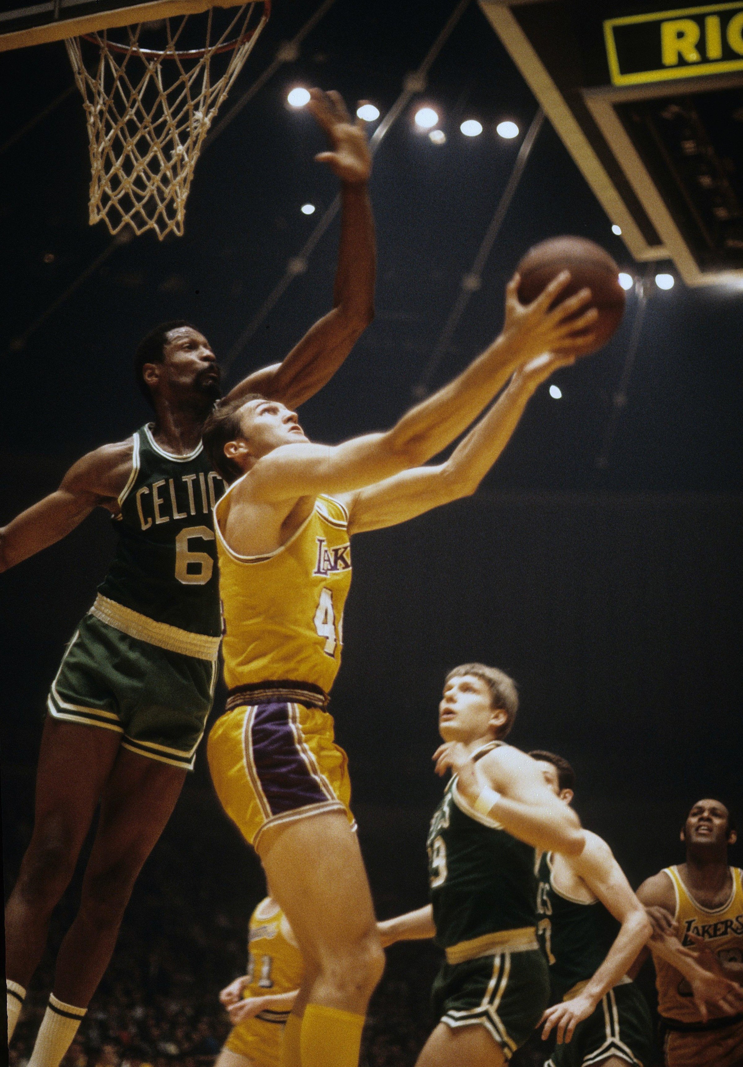 Jerry West of the Lakers attempts a reverse layup against Bill Russell. (Photo by Focus on Sport/Getty Images)