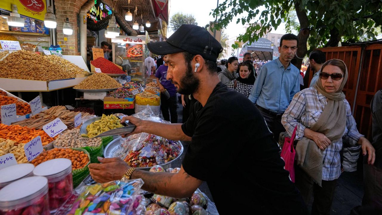 A shopkeeper arranges snacks at his shop at Tehran's Grand Bazaar in Tehran, Iran, Tuesday, Aug. 25, 2026. (AP Photo/Vahid Salemi)