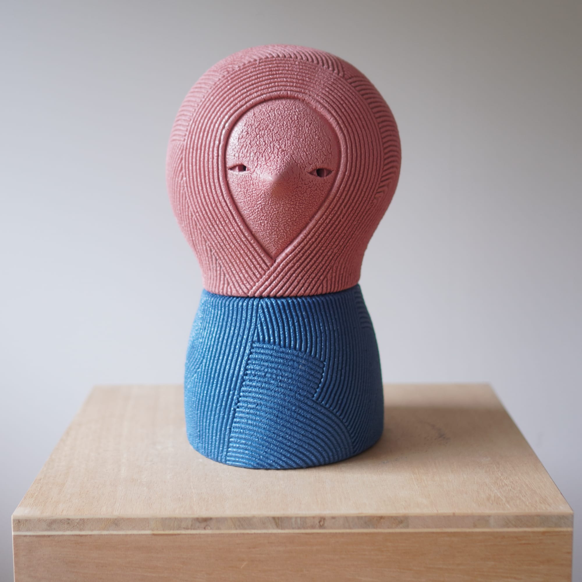 an abstract ceramic sculpture by en iwamura with a tiny face