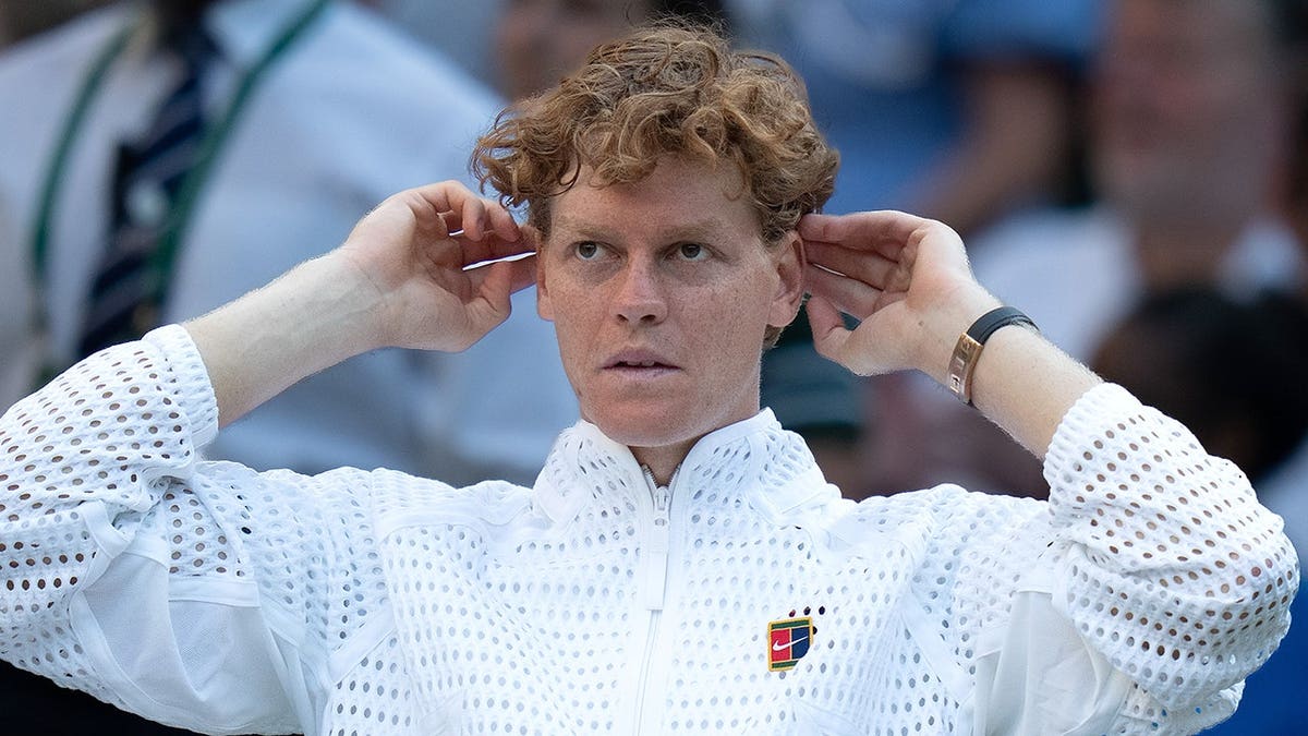 Jannik Sinner of Italy stands after winning the men's singles final at All England Lawn Tennis and Croquet Club.
