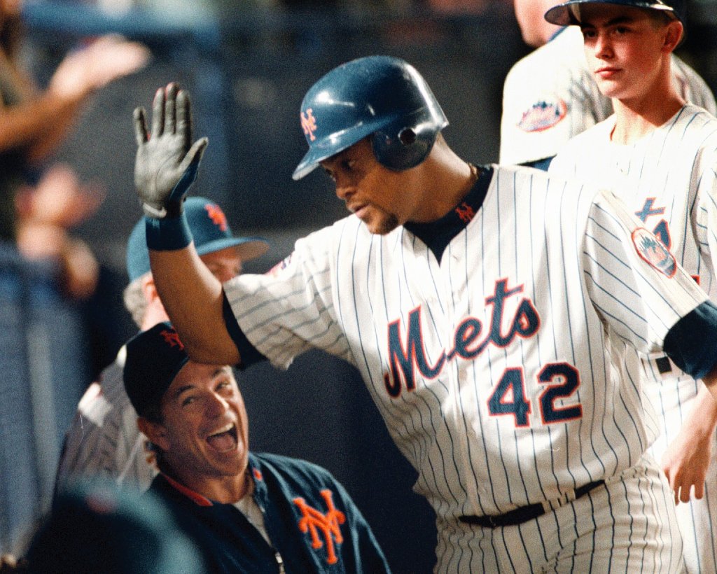 Mets manager Bobby Valentine enthusiastically high-fives player Butch Huskey after a home run.