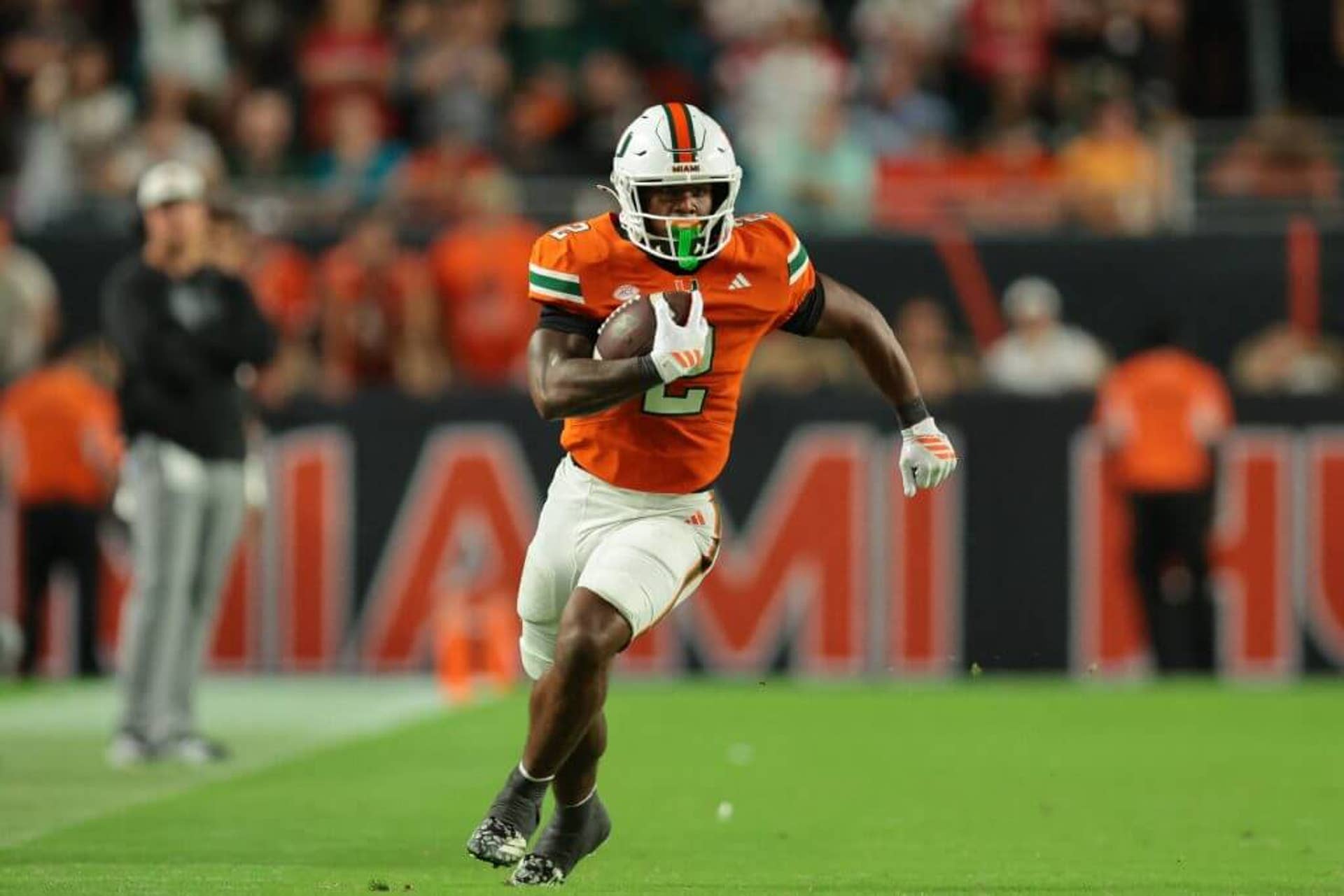 Miami running back Jordan Lyle carries the football against Louisville.