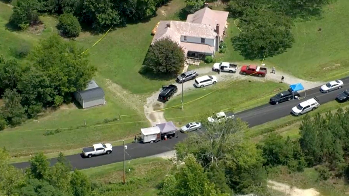 An aerial view of a house with cars parked in front