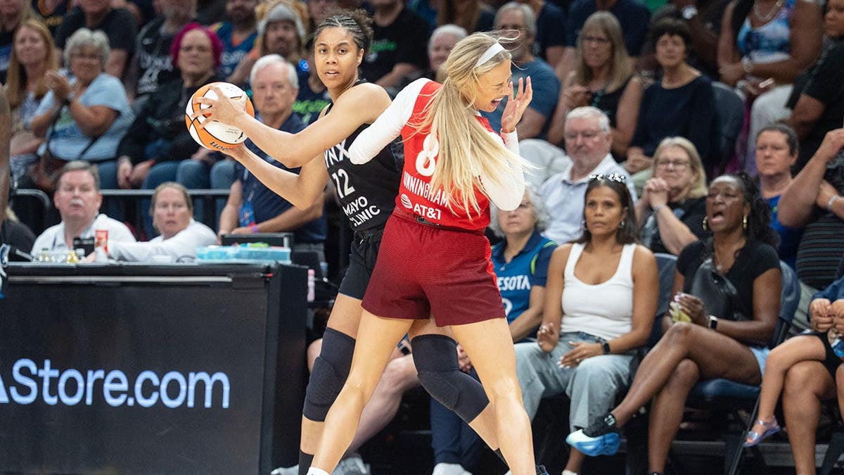 Nia Coffey and Sophie Cunningham collide during a WNBA game at Target Center.