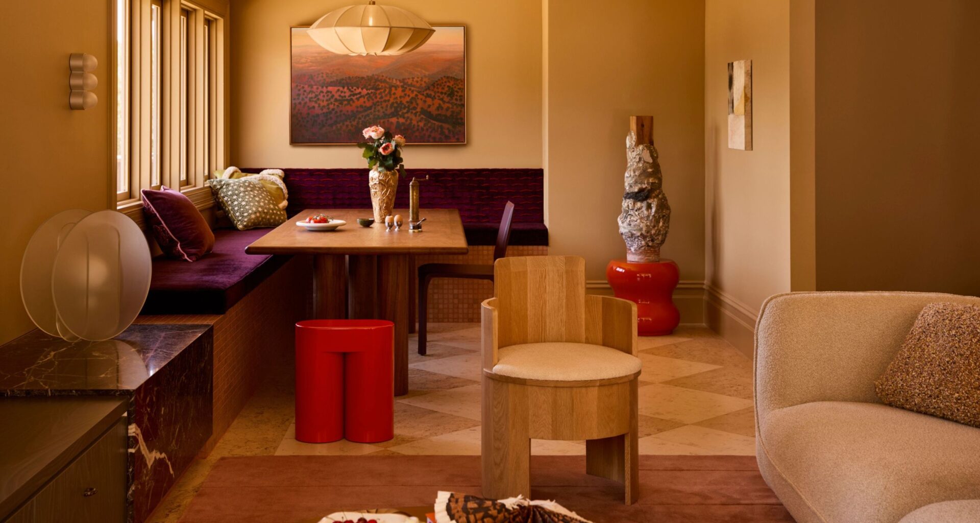 a neutral color drenched living area with a built in purple banquette seat and checkerboard flooring