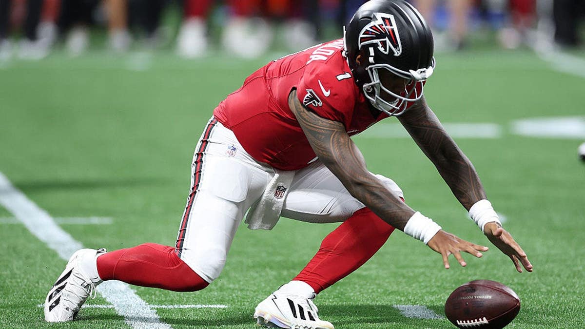 Tua Tagovailoa recovers a fumble during an NFL preseason game.