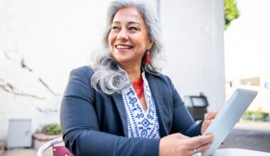 Smiling person holding tablet.