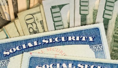 Two Social Security cards in front of a pile of cash.