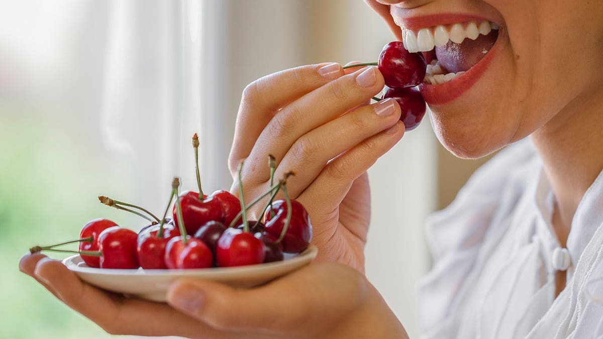 Woman eating cherries.