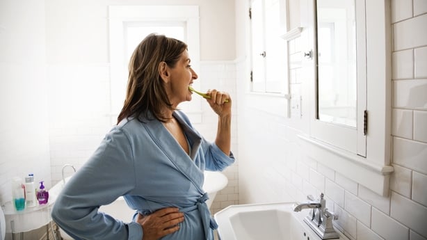 mature woman brushing her teeth