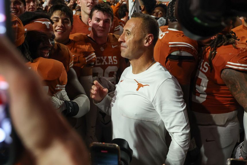Texas head coach Steve Sarkisian stands with players after the game.