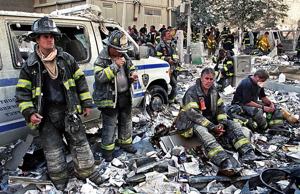 Firefighters resting amid the rubble after the World Trade Center attacks.