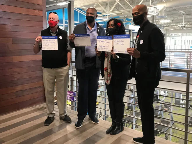 Former U of L basketball standouts (from left) Roger Burkman, Scooter McCray, Valerie Combs and Darrell Griffith showed off signs showing they were all vaccinated against COVID-19 last week at the West Broadway YMCA.