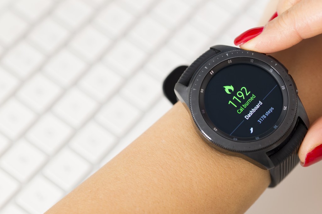 A person's wrist with a smartwatch displaying 1192 calories burned and 3178 steps.