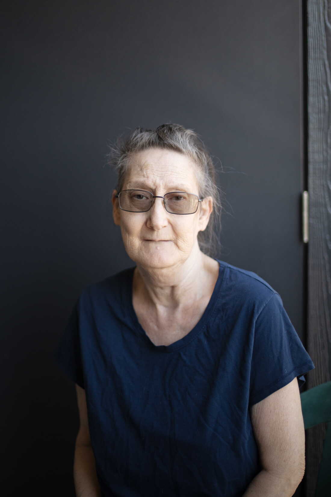 Debbie Willson is wearing a dark T-shirt and glasses.