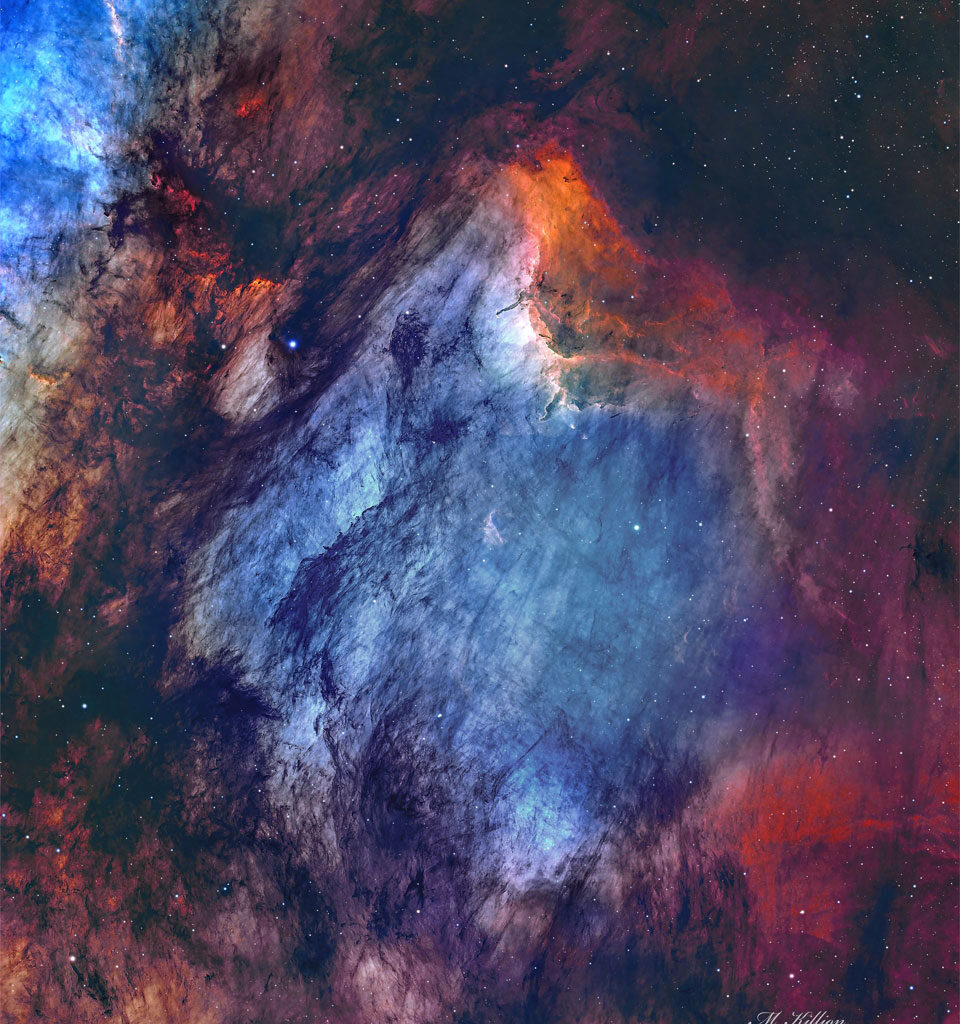 A busy starfield is dominated by red and blue glowing
gas and dark filamentary dust. The nebula appears to some
to have the shape of a pelican.
Please see the explanation for more detailed information.