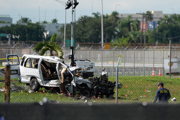 An NTSB investigator works near a damaged van at the site where an Amazon cargo plane overshot the runway two days earlier while landing at Miami International Airport, Tuesday, Sept. 8, 2026, in Miami. (AP Photo/Rebecca Blackwell)