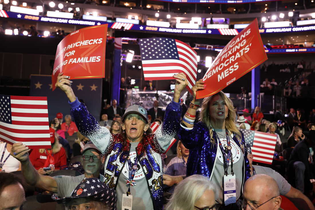 People hold signs on the first day of the 2026 Republican National Convention Sept. 9 in Dallas, Texas. President Donald Trump will headline the Republican National Committee's first-ever midterm convention Wednesday night.