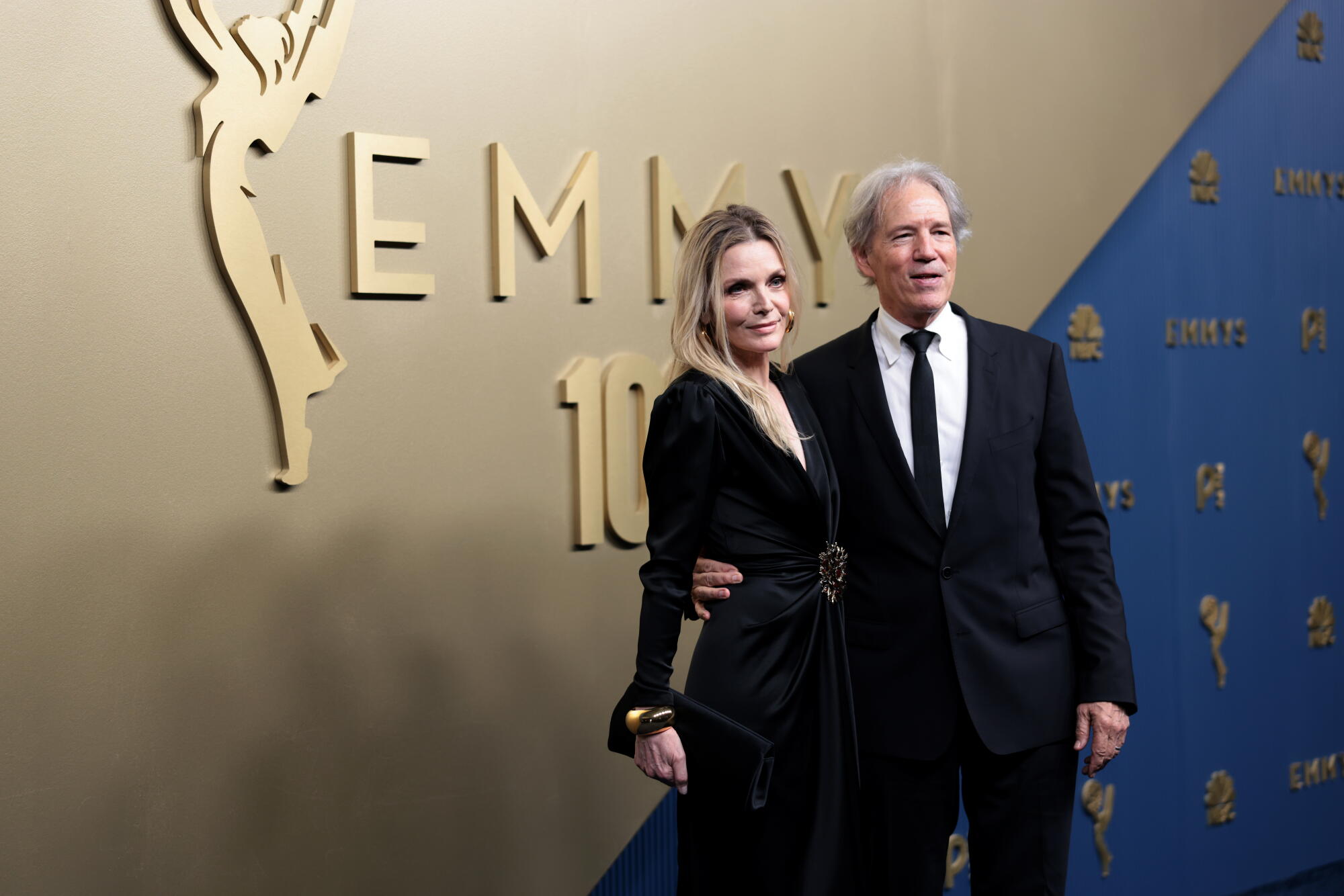 Michelle Pfeiffer and David E. Kelley pose on the Emmys blue carpet.
