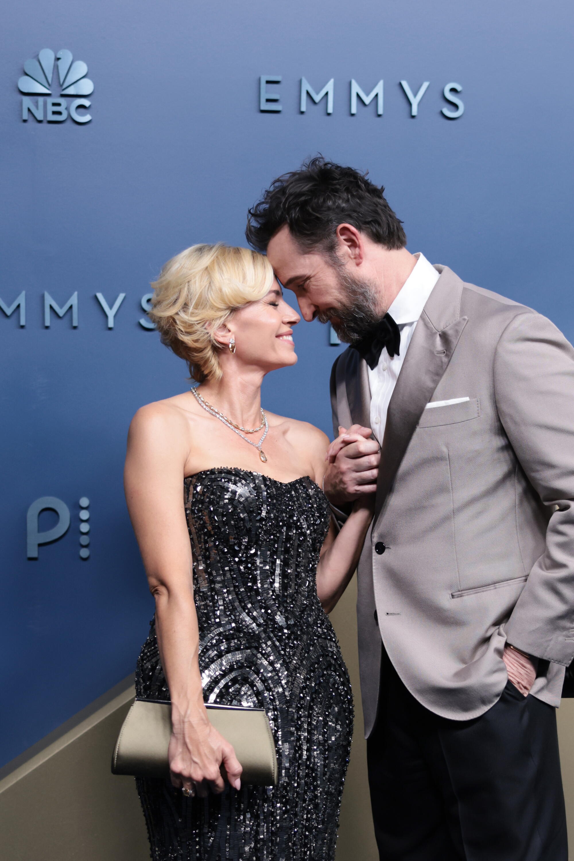 Sara and Noah Wyle touch foreheads on the Emmys blue carpet. 